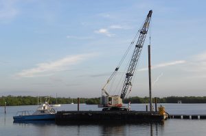 Florida Marine Construction installing 55 foot concrete anchor piling for floating docks in Naples, Florida.
