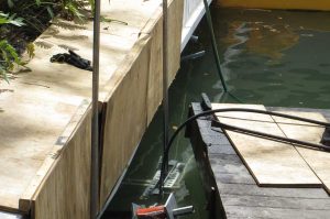 Installing Helical anchors beneath tide line to sustain concrete seawall.