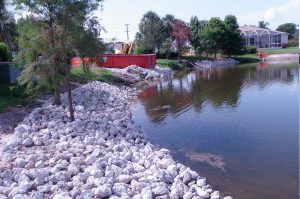 Installation of clean washed lime rock rip-rap along lake shoreline.
