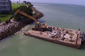 Long Reach Excavator placing 3 ton armor stone on shoreline.